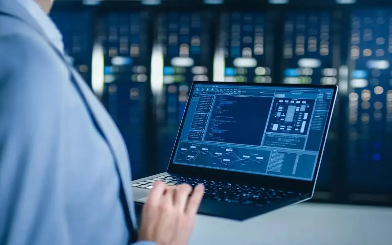 Analista del SOC de LumaCloud monitoreando amenazas desde un laptop en un datacenter